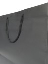 Schwarze Papiertüte mit schwarzen Kordelgriffen